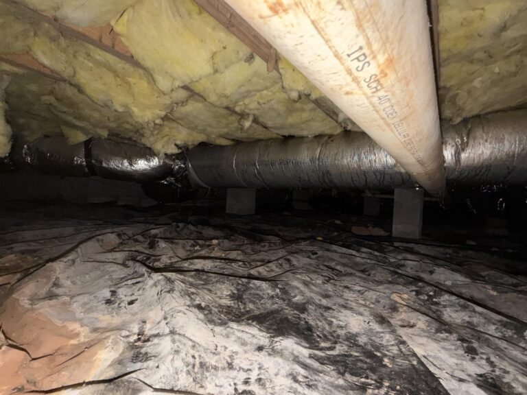 Sealed crawlspace floor liner under a home with insulated ductwork overhead